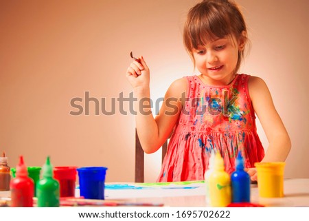 Little cute child girl artist with brush painting picture. Creativity and happy childhood concept.