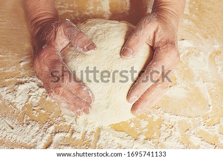 Female hands hold kneading bread dough top view. Homebaked bread.