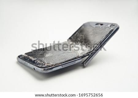 Mobile smartphone with broken screen on white background.