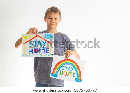 Kid holding drawing pictures with words Stay at home. Social media campaign for coronavirus prevention