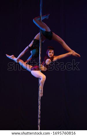 young girls athlete gymnast shows an acrobatic performance on a pylon.