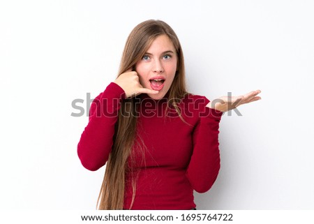 Teenager blonde girl over isolated white background making phone gesture and doubting