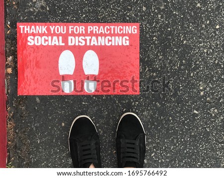 Social distancing sign for people line up in front of grocery store or retailer store  to reduce risk of crowded gathering in store during Covid-19 or Coronavirus crisis  Royalty-Free Stock Photo #1695766492