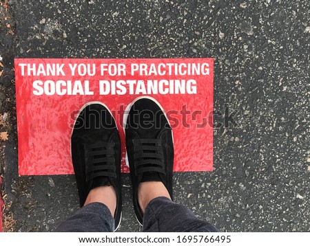 Social distancing sign for people line up in front of grocery store or retailer store  to reduce risk of crowded gathering in store during Covid-19 or Coronavirus crisis  Royalty-Free Stock Photo #1695766495