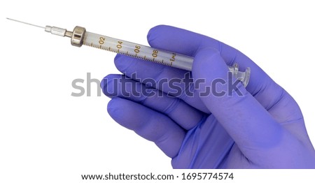 syringe and needle in hand in medical glove on a white background