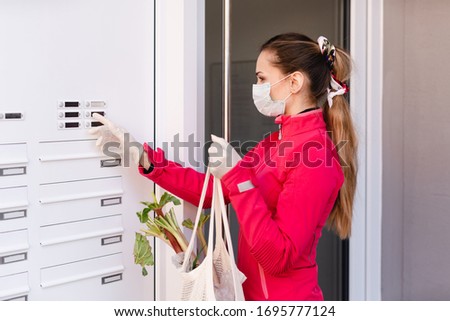 Young woman helping neighbors by shopping groceries for people in covid-19 quarantine Royalty-Free Stock Photo #1695777124