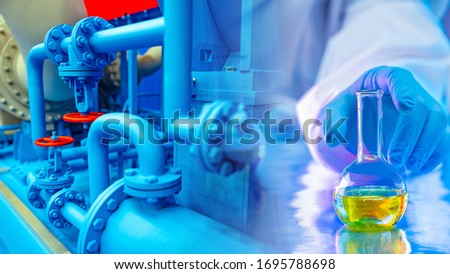 Pipes in the enterprise. Factory for the production of chemicals. Concept sample taken in production. In vitro fluid. Test tube with chemical fluid. A person reaches for the test tube. Industry