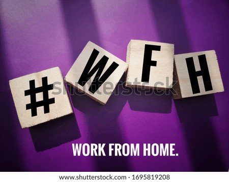 concept image a wooden block and word - WORK FROM HOME ( #WFH ) on purple background. Selective focus.

