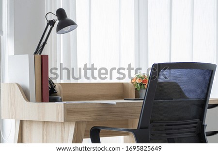 Minimal interior of working room at home, there is wooden table and black armchair