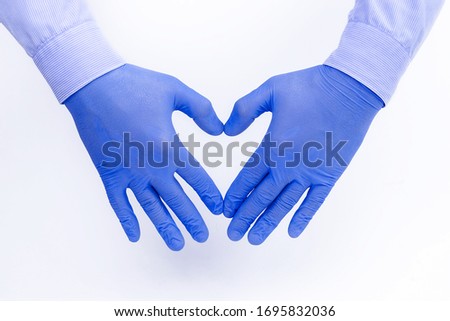 Hands of a caring doctor in medical gloves on a white background show a heart with their fingers, a professional takes care of our health: a medical concept, a place for text