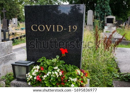 Graveyard cemetery black granite headstone with COVID-19 letters carved in, Coronavirus pandemic crisis taking many lives, deadly virus death toll rising, high mortality rate, acute pneumonia victims Royalty-Free Stock Photo #1695836977