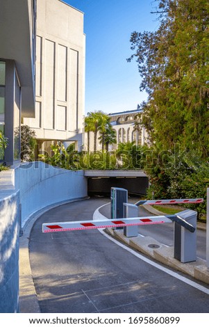 A vertical picture of boom barriers of underground parking surrounded by buildings in Switzerland