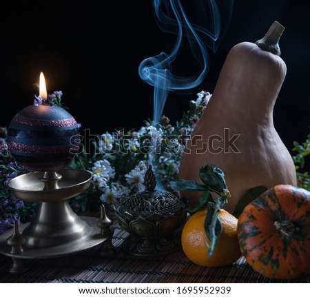 Still life with a pumpkin, candle and smoke from a beautiful metal box, fortune teller's table on Halloween