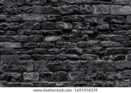 Aged grungy coarse stonework city. Modern black art decor cellar house.Bumpy vintage facing granite fortress 3D design.Carved rural facade fortified tower.Backdrop of burnt ground floor castle dungeon