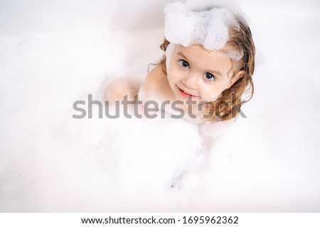 
little girl takes a bubble bath Royalty-Free Stock Photo #1695962362
