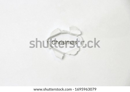Word christmas on white isolated background, the inscription through the wound hole in the paper. Stock photo for web and print with empty space for text and design.