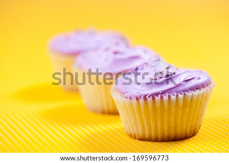 Raspberry muffin with vanilla filling against yellow background