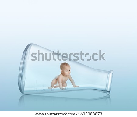 Little baby in conical flask on light background