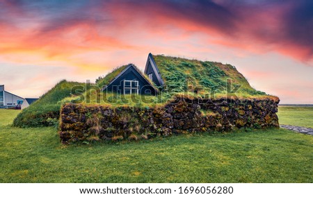 Typical view of turf-top houses in Icelandic countryside. Captivating summer sunset in Skogar village, south Iceland, Europe. Traveling concept background.