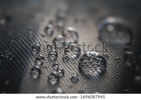 Many water drops on waterproof impregnated fabric of black umbrella. Royalty-Free Stock Photo #1696087945
