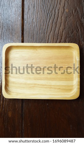 Close-up blank rectangular Asian style serving wooden tray on dark brown table at fresh market gourmet restaurant, graphic design component, rough texture backgrounds