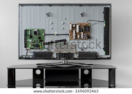 Disassembled TV is on a black table, prepared for repair. Column below. Royalty-Free Stock Photo #1696092463