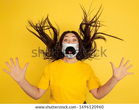 Crazy shocked. Portrait of young caucasian woman with emotion on her protective face mask isolated on studio background. Beautiful female model. Human emotions, facial expression, sales, ad concept.