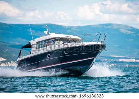 A black hull speedboat racing by sea Royalty-Free Stock Photo #1696136323