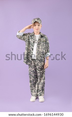 Cute saluting little soldier on color background