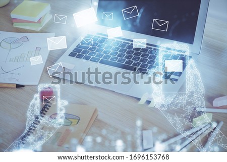 Desktop computer background in office and flying envelops hologram drawing. Multi exposure. Electronic mail concept.