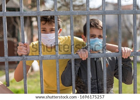 Children in quarantine playing at the season of the COVID-19 (corona-virus) with  surgical masks
