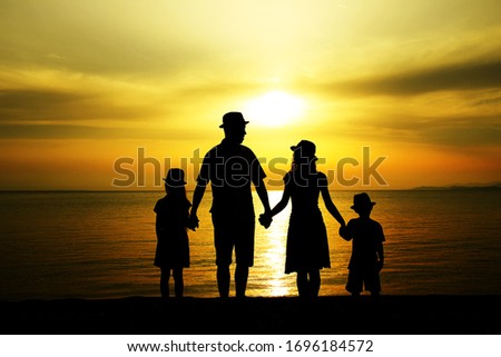 happy family silhouette at sunset by the sea