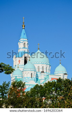 Domes and bell tower of the Transfiguration Cathedral on the background of a clear, blue sky. Valaam Orthodox Transfiguration Monastery in the green of trees on a summer day, vertical photo. Valaam 