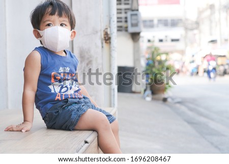 Little boy wear white mask protect Pm2.5 amd covid 19 sitting in cafe, Healthy concept