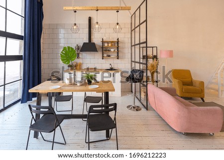 luxury modern design of a cozy small Scandinavian-style studio apartment with white walls, second floor with a library and huge high window full of day light Royalty-Free Stock Photo #1696212223