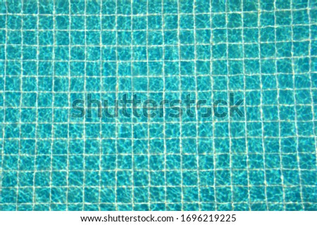 The view from the top or bird's-eye view of the pool with rippling water and the blue tiled floor of the pool.