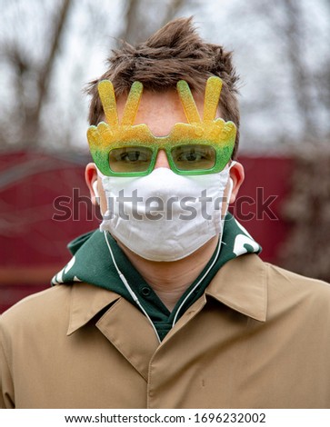 Portrait of a young man in a protective medical mask and funny sunglasses . Preventive measures in the case of a coronavirus epidemic.