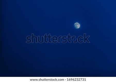 The moon in the night sky. Blue sky and white moon, night background.