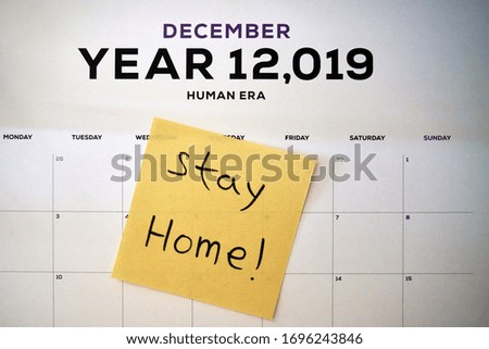 Yellow sticky notes with text Stay Home on a human era calendar, self isolation and home quarantine from Covid-19 coronavirus 