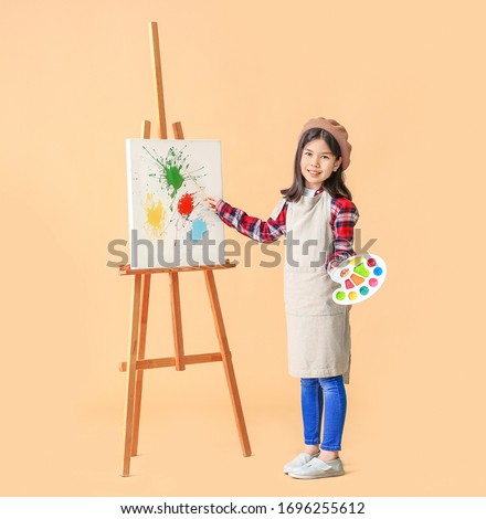 Cute little artist on color background Royalty-Free Stock Photo #1696255612