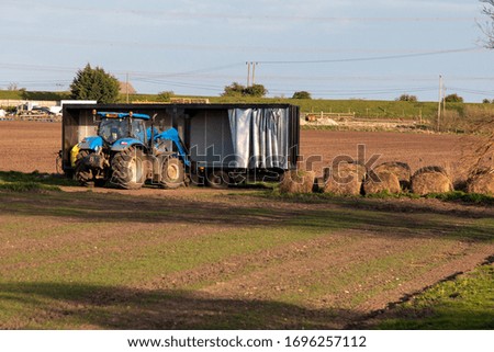 Tractor and trailer working in field