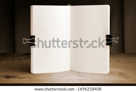 Notebook mockup on a background of wooden table and drapery