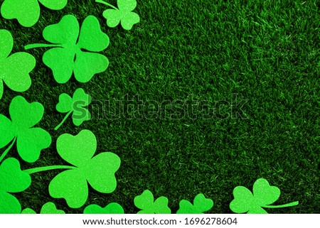 Flat lay composition with clover leaves on green grass, space for text. St. Patrick's Day celebration