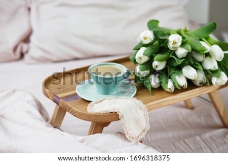 Romantic morning.A coffee table in a pink bed, a Cup of coffee and flowers on the table. Valentine's day. 