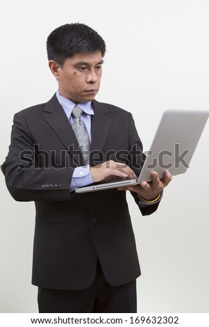 Portrait of  young businessman using laptop. Vertical shot. Isolated on white.