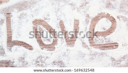 Writing the word love on the  wooden table with meal 