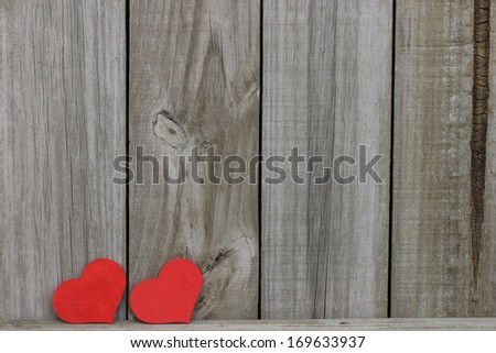 Two red hearts against wood background