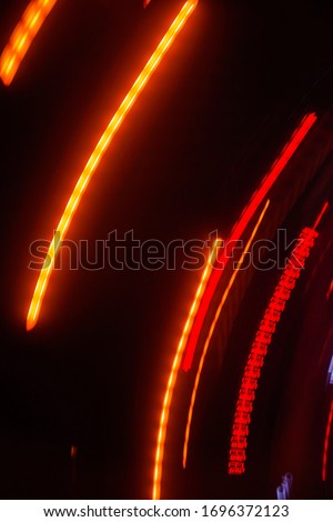 Lights and stripes moving fast over dark background. Orange and bluel backdrop from fast moving glow particles.