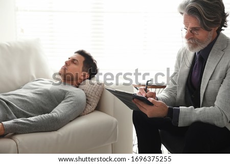 Psychotherapist and patient in office. Hypnotherapy session Royalty-Free Stock Photo #1696375255