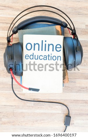 Audio book concept. Headphones and books on wooden table. Top view with copy space, online education concept